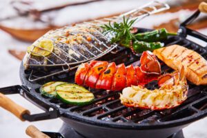 lobster tails cooking on a grill