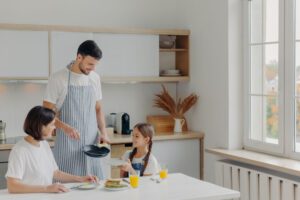 father preparing breakfast for wife and daughter