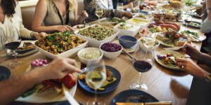 people eating at dinner table with various side dishes