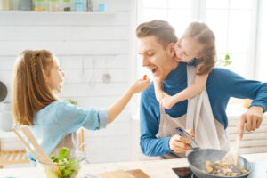 father and daughters cooking mother's day dinner