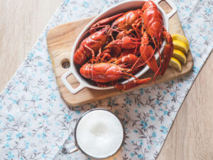 Red crayfish with lemon. In the background, beer is poured into a glass.